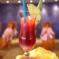 Rot-gelber Cocktail mit Ananas und blauen Strohhalmen in der Gastronomie im Freizeitbad LA OLA