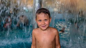 Ein Junge steht unter einem Wasserpilz in der Wasserwelt.